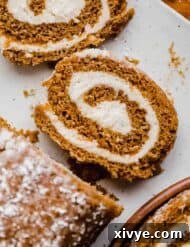 A slice of pumpkin roll made with Libby's pumpkin puree and filled with cream cheese frosting, on a white plate.