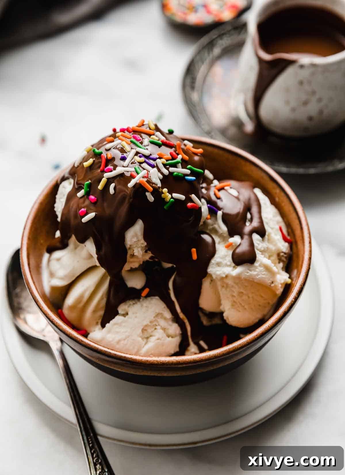 Vanilla ice cream in a brown bowl topped with homemade magic shell recipe and colorful sprinkles.