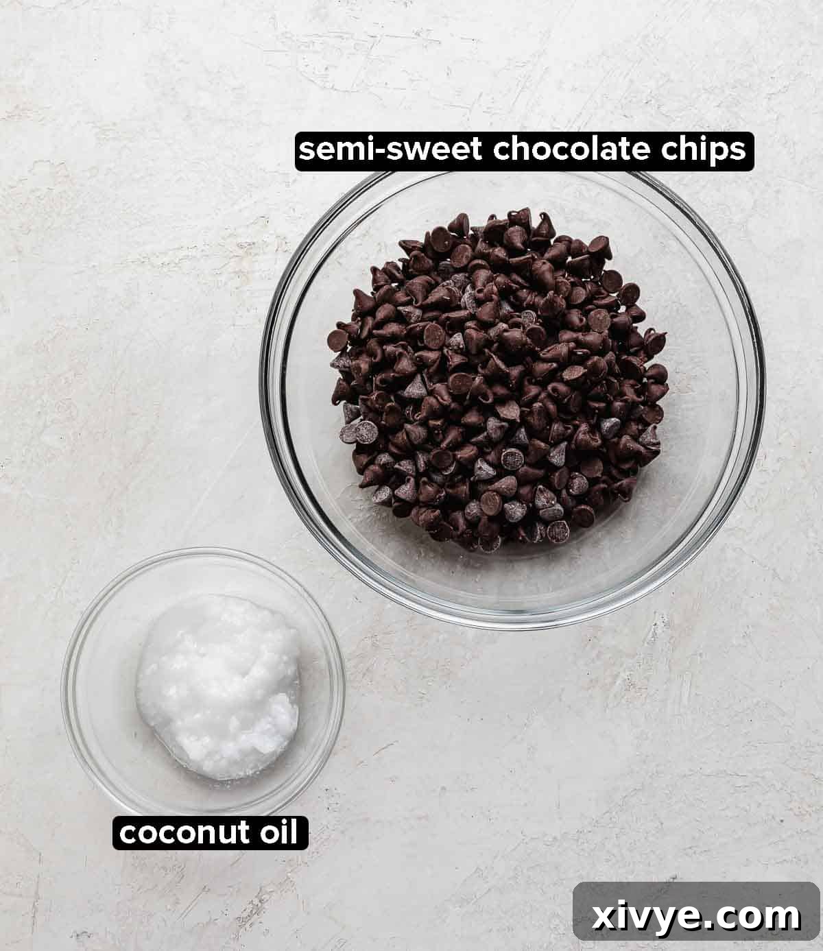Magic Shell ingredients on a gray background: semi sweet chocolate chips and coconut oil.