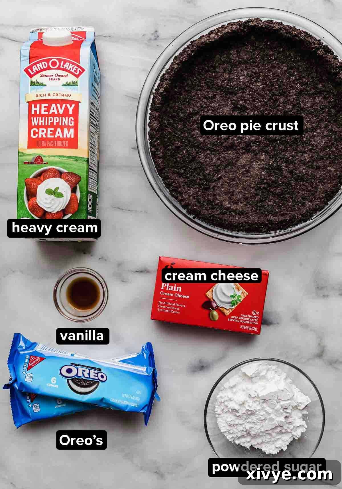 Cookies and Cream Pie (Oreo pie) ingredients on a white background: heavy cream, Oreo pie crust, Oreos, cream cheese, powdered sugar, vanilla.