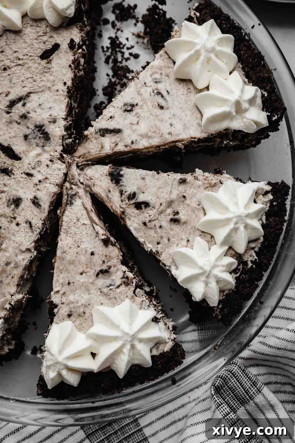 Overhead photo of three slices of Cookies and Cream Pie topped with whipped cream piped topping around the edges of the pie.