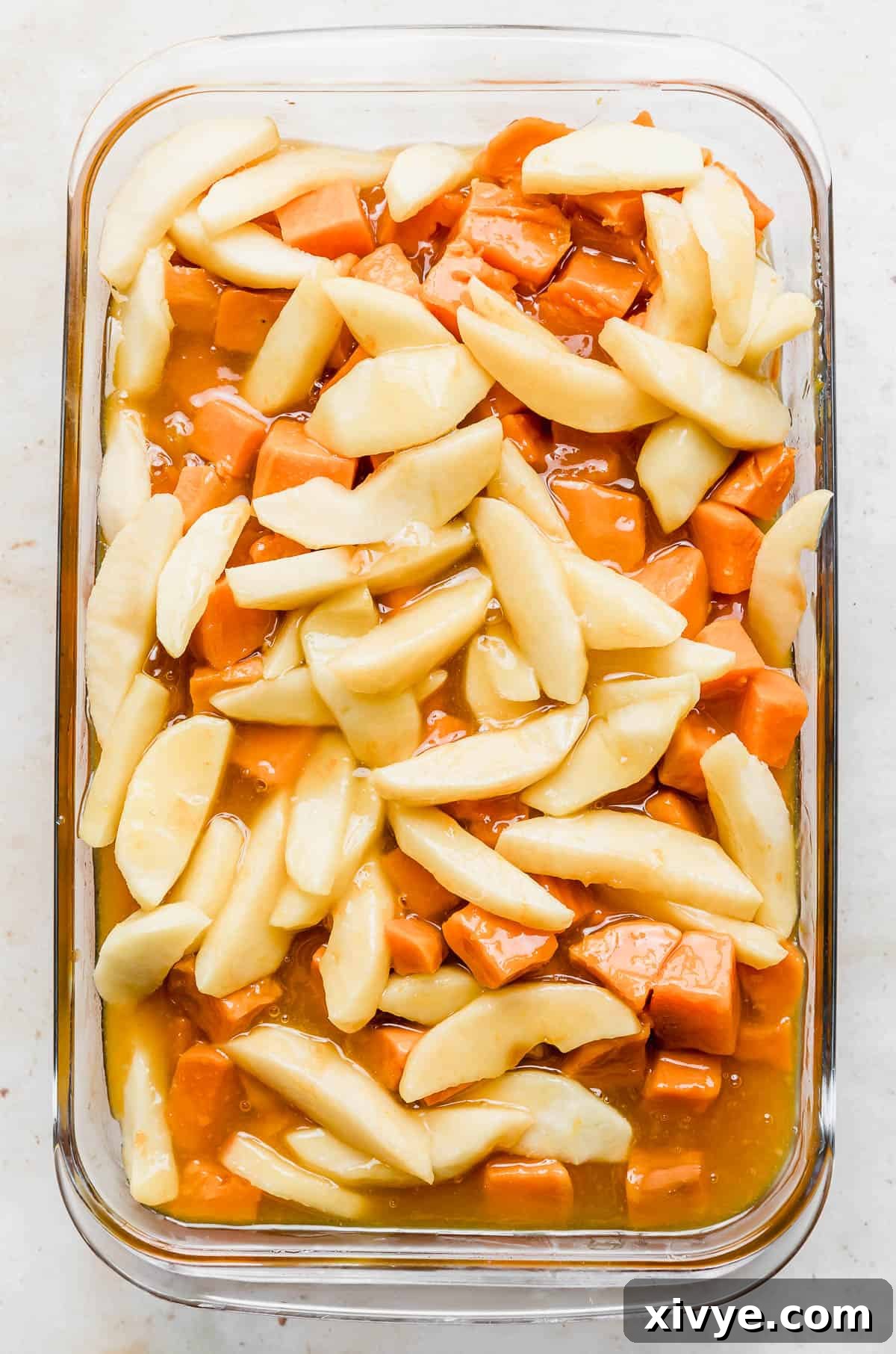 The finished Candied Yams with Apples, beautifully baked and glistening in a glass baking dish, ready to be served as a stunning holiday side.