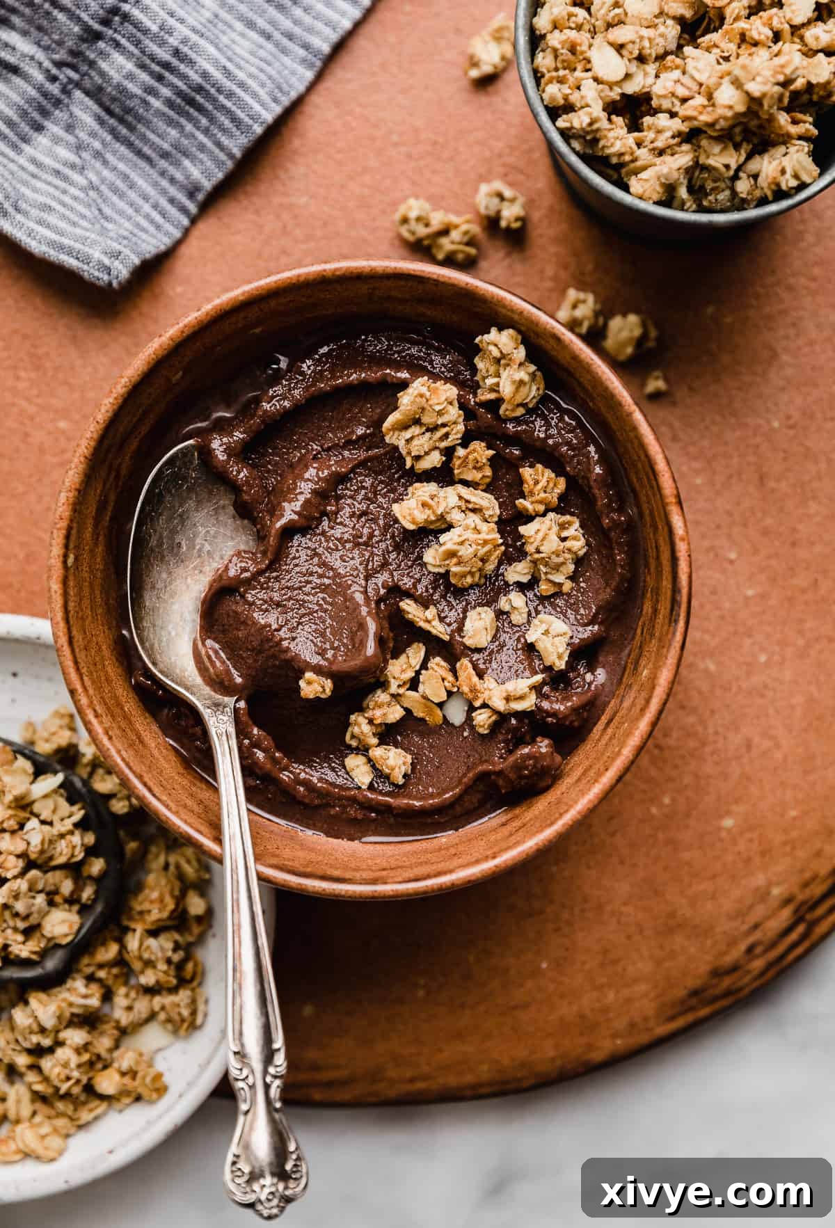 Decadent Chocolate Acai Bliss 2 Chocolate Acai smoothie in a brown bowl topped with granola.