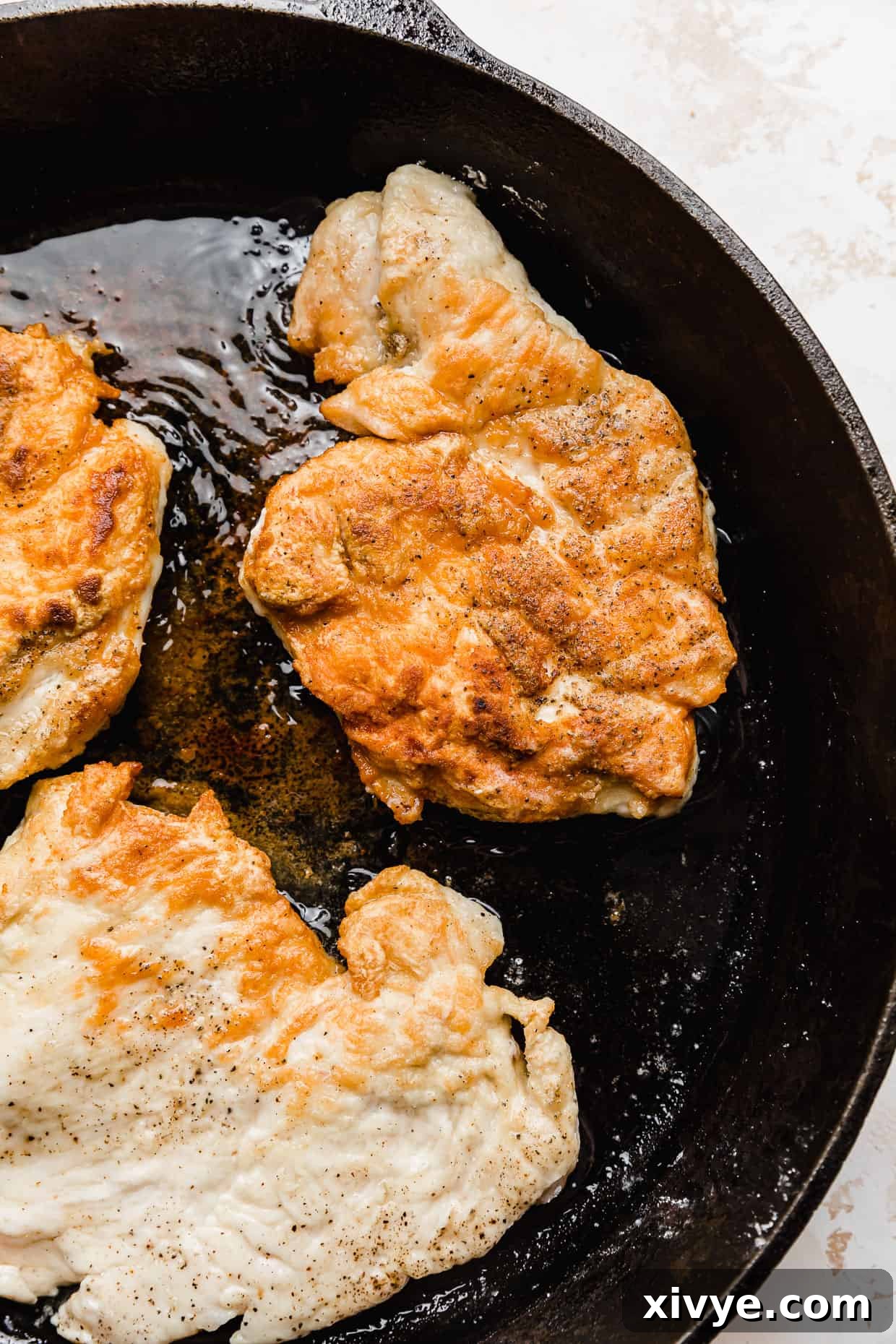 Caribbean Curried Chicken with Coconut Rice and Beans 5 Seared chicken breast in a black skillet, perfectly browned.