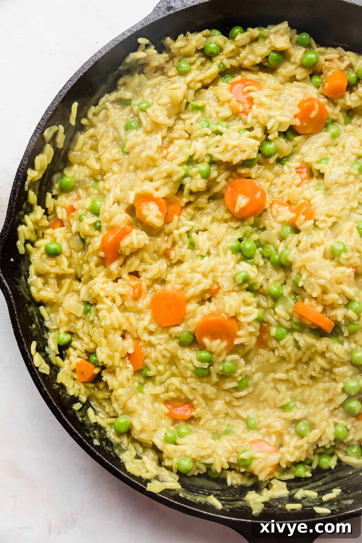 Caribbean Curried Chicken with Coconut Rice and Beans 9 Skillet curry chicken and rice with carrots and peas, garnished with fresh cilantro, ready to eat.
