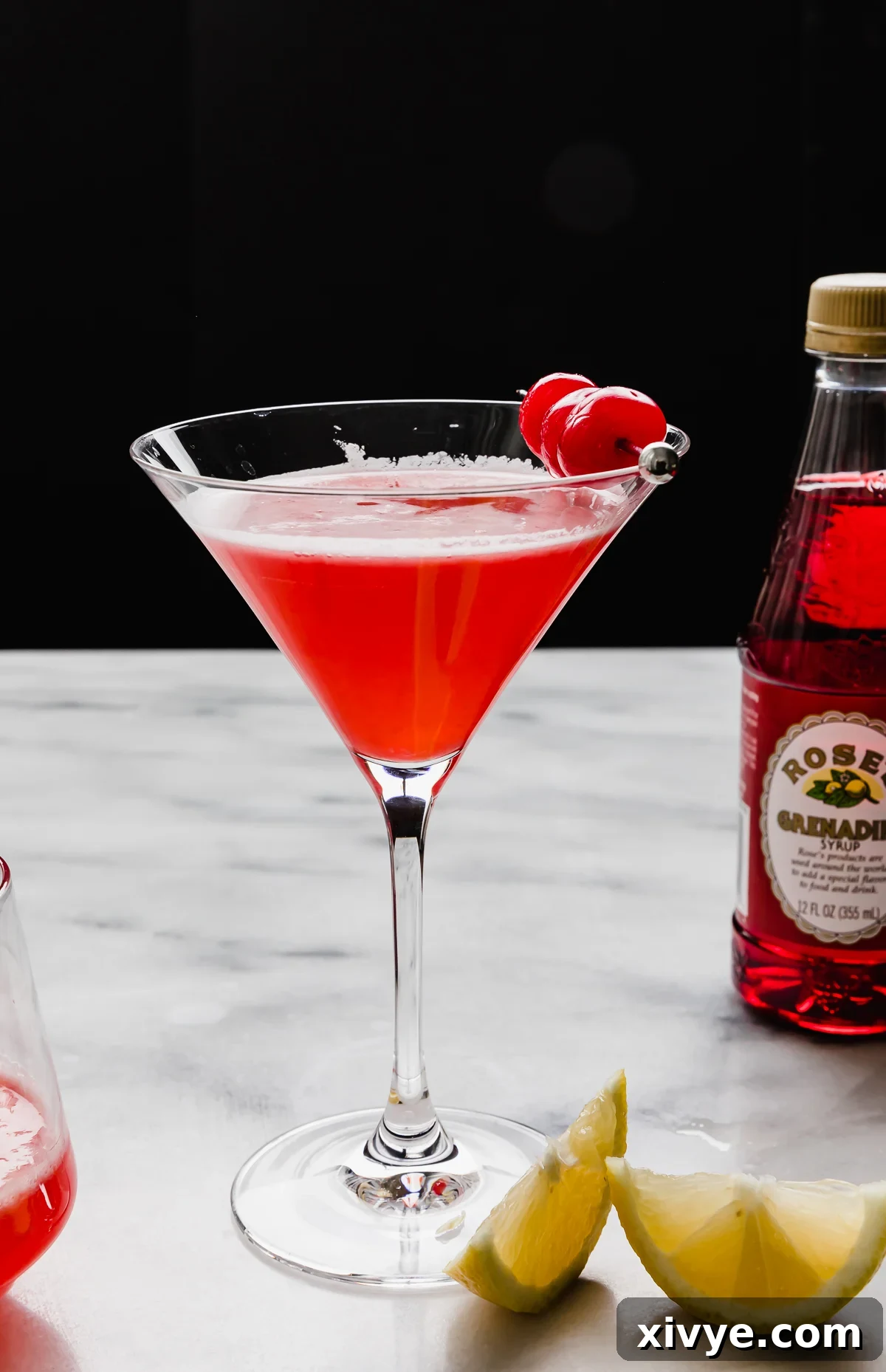 Pink Elegance Sparkler 6 A pink lady cocktail without alcohol in a martini glass against a black background.