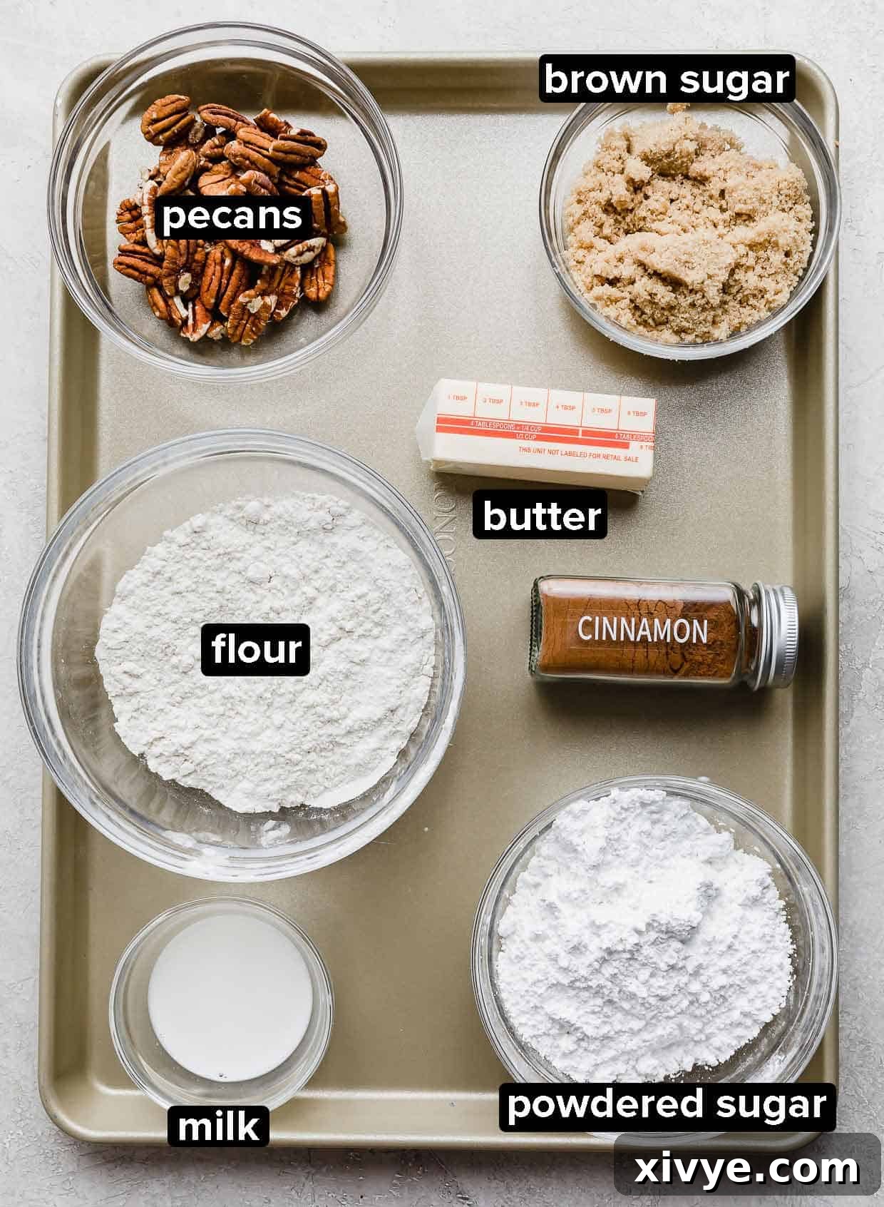 Golden Pumpkin Pecan Crumble Coffee Cake 4 Separate ingredients for the pecan streusel topping, including flour, brown sugar, cinnamon, cold cubed butter, and chopped pecans, displayed on a baking sheet.