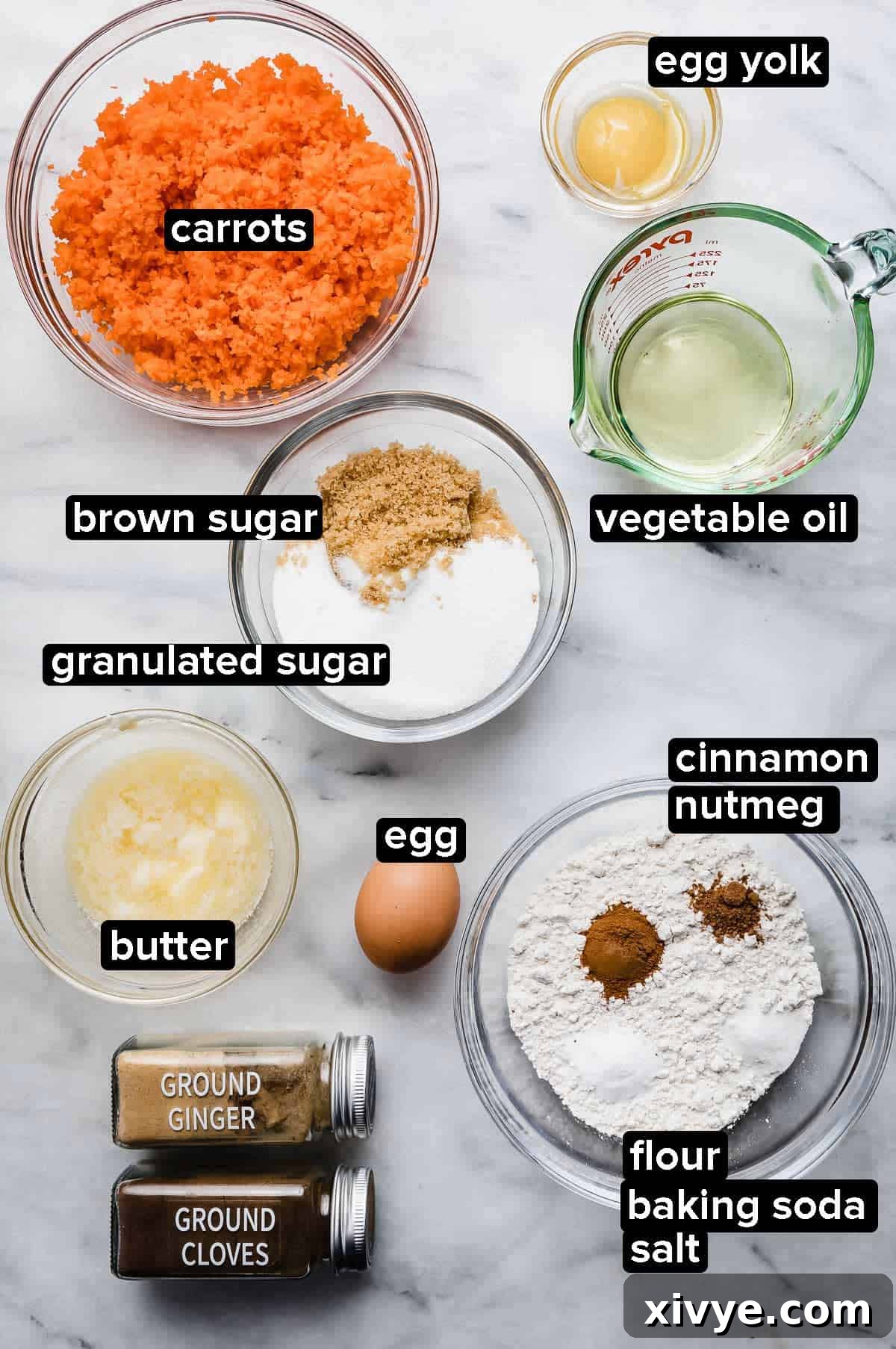 Spiced Carrot Crumb Cake 3 Carrot Coffee Cake ingredients portioned into glass bowls on a white marble background, showing shredded carrots, oil, sugars, melted butter, flour, eggs, cinnamon nutmeg, cloves, and ginger.