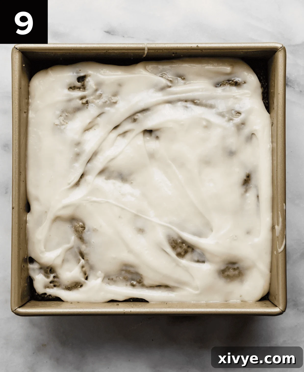 Spiced Carrot Crumb Cake 7 Carrot coffee cake topped with cream cheese frosting in a square pan.