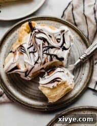 Overhead photo of the best cream puff cake on a gray plate resting on a tan and blue striped linen napkin.