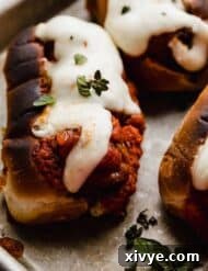 Saucy Italian Meatball Heroes 8 The best Italian Meatball Subs topped with melted cheese, on a baking sheet.