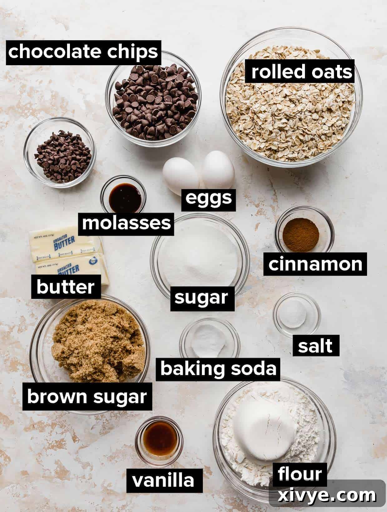 A collection of ingredients artfully arranged on a white background, ready to be transformed into delicious Oatmeal Chocolate Chip Cookies.