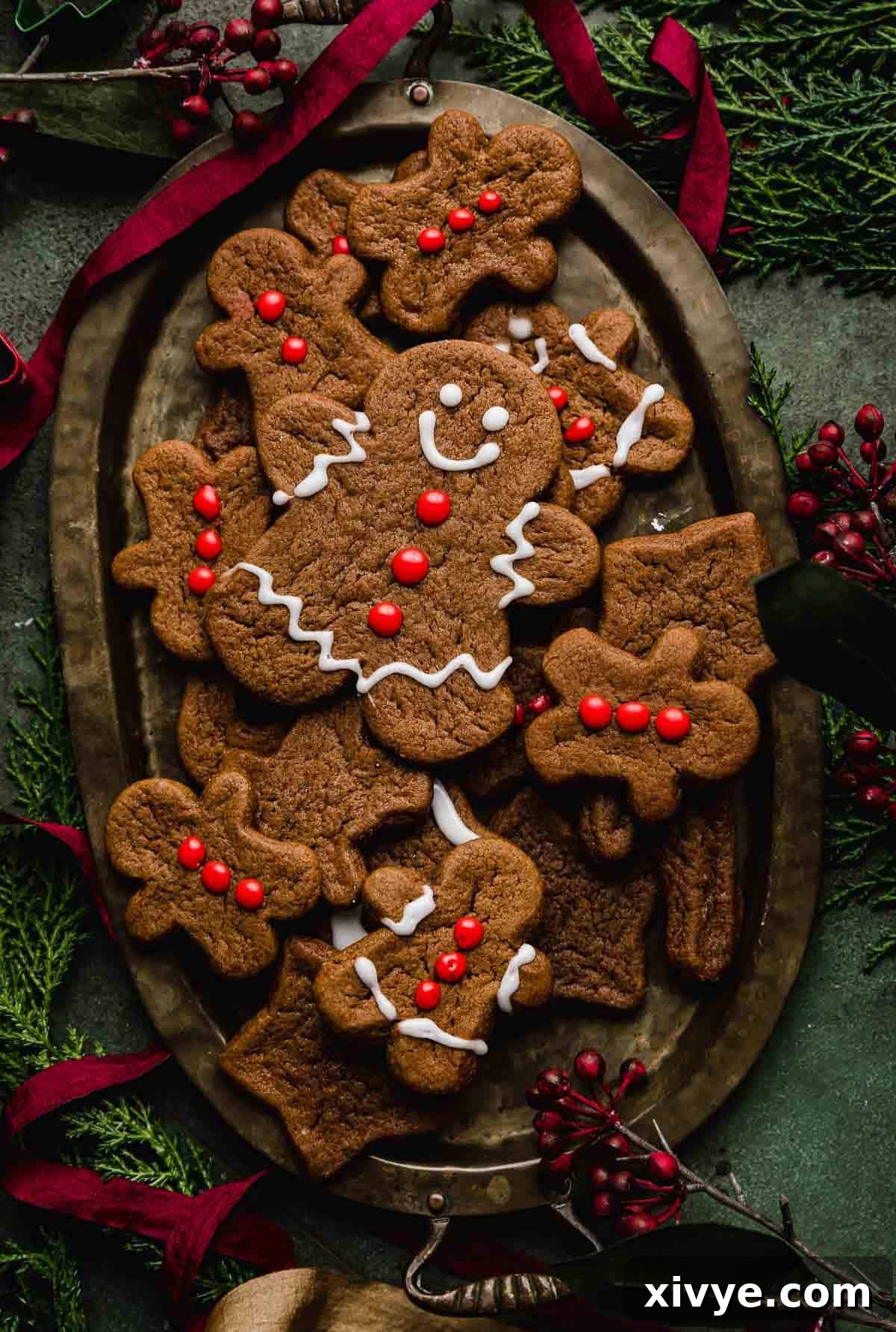 An oval bronze plate with Soft Gingerbread Cookies on it on a dark green background.