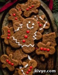 A cute gingerbread man cookie decorated with red frosting buttons and white eyes and smile.