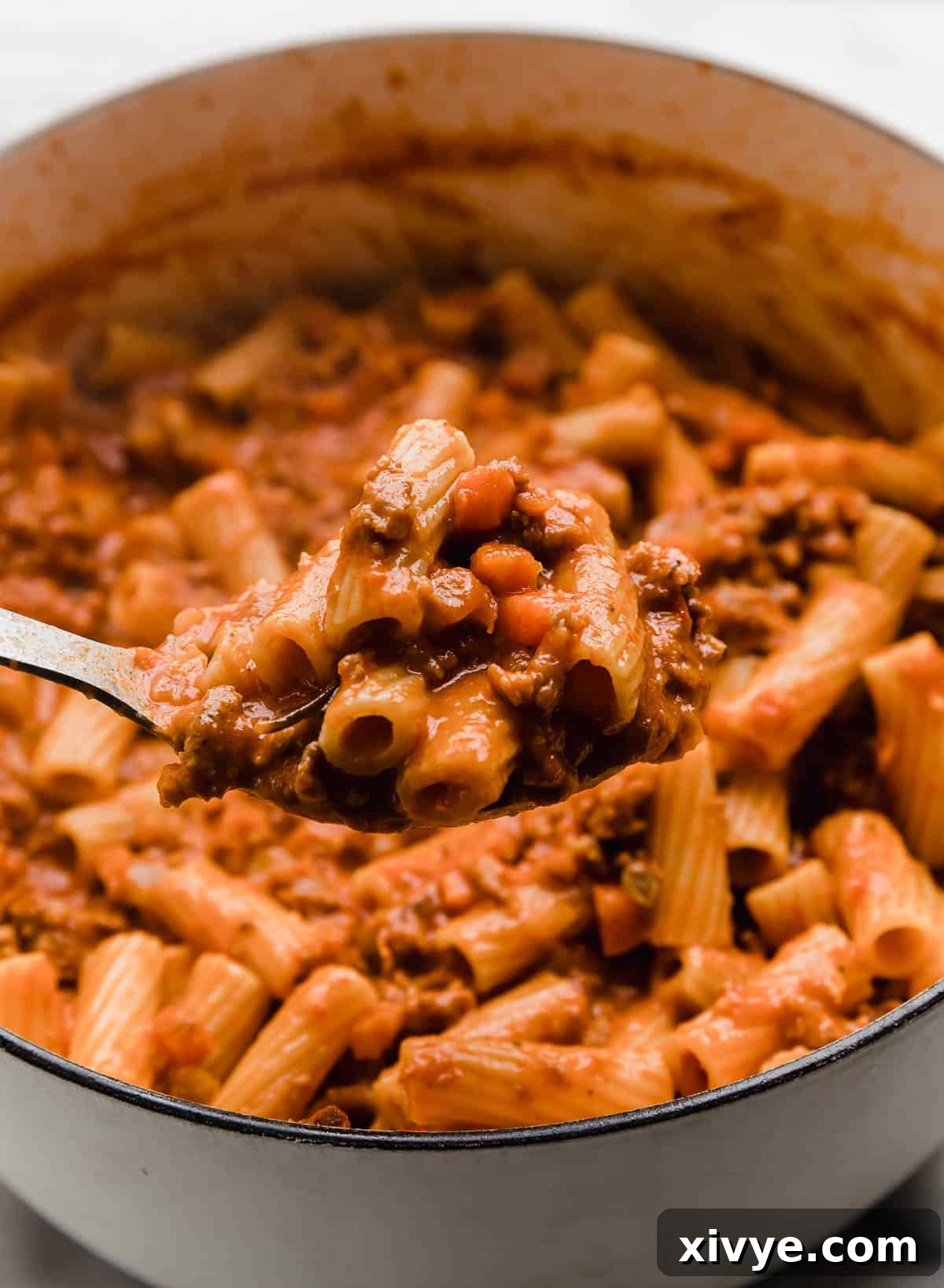 Rustic Sausage Ragu 7 A serving spoon scooping up an easy sausage ragu recipe from a pot, highlighting its rich texture.