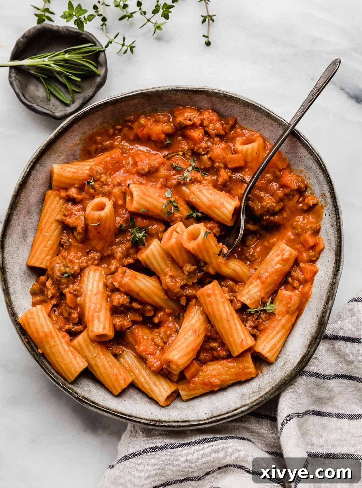 Rustic Sausage Ragu 8 The best Sausage Ragu recipe in a gray pasta bowl with a fork piercing some of the rigatoni noodles, inviting a delightful meal.