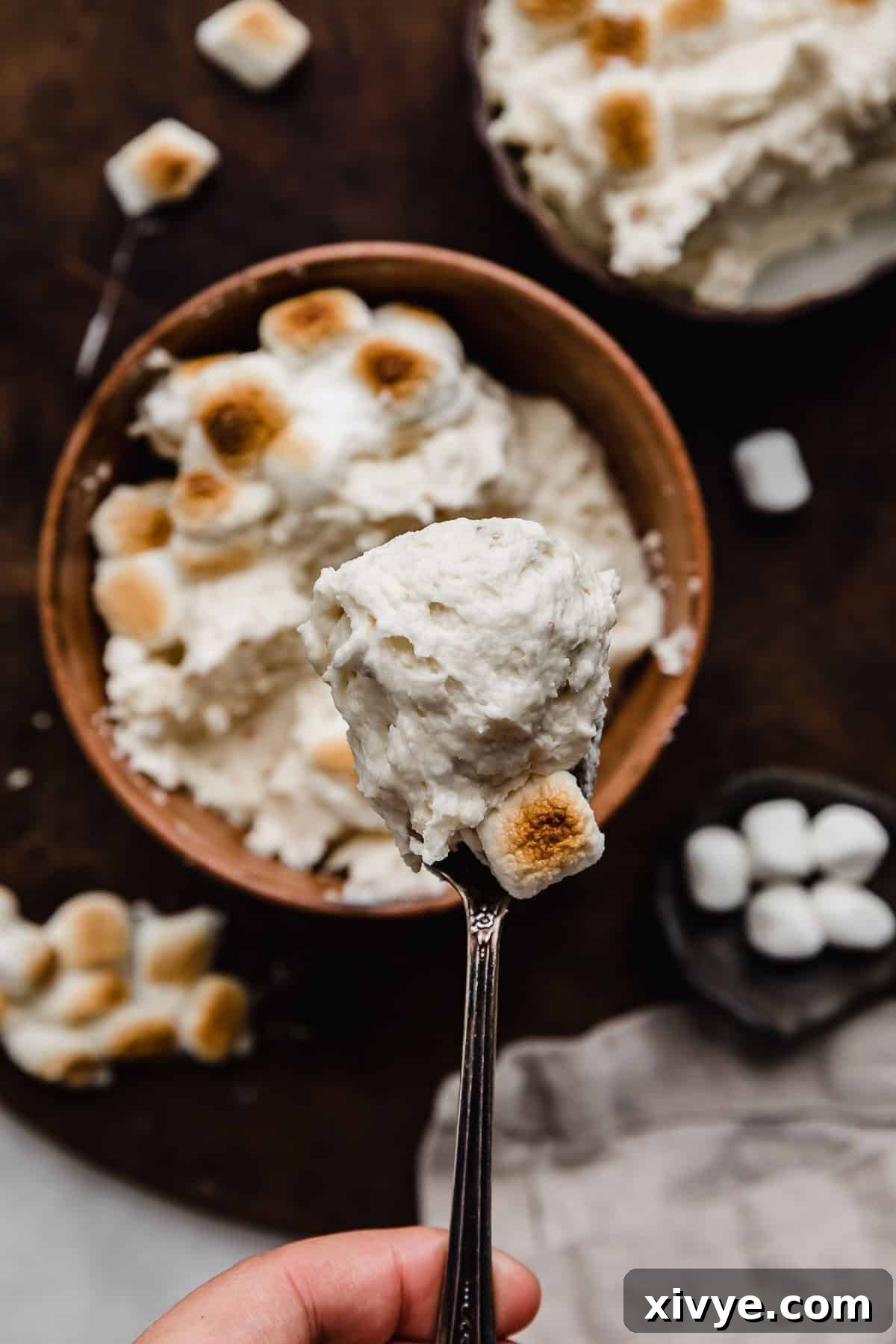 Toasted Marshmallow Frosting served on a spoon, showcasing its creamy texture and inviting appearance.