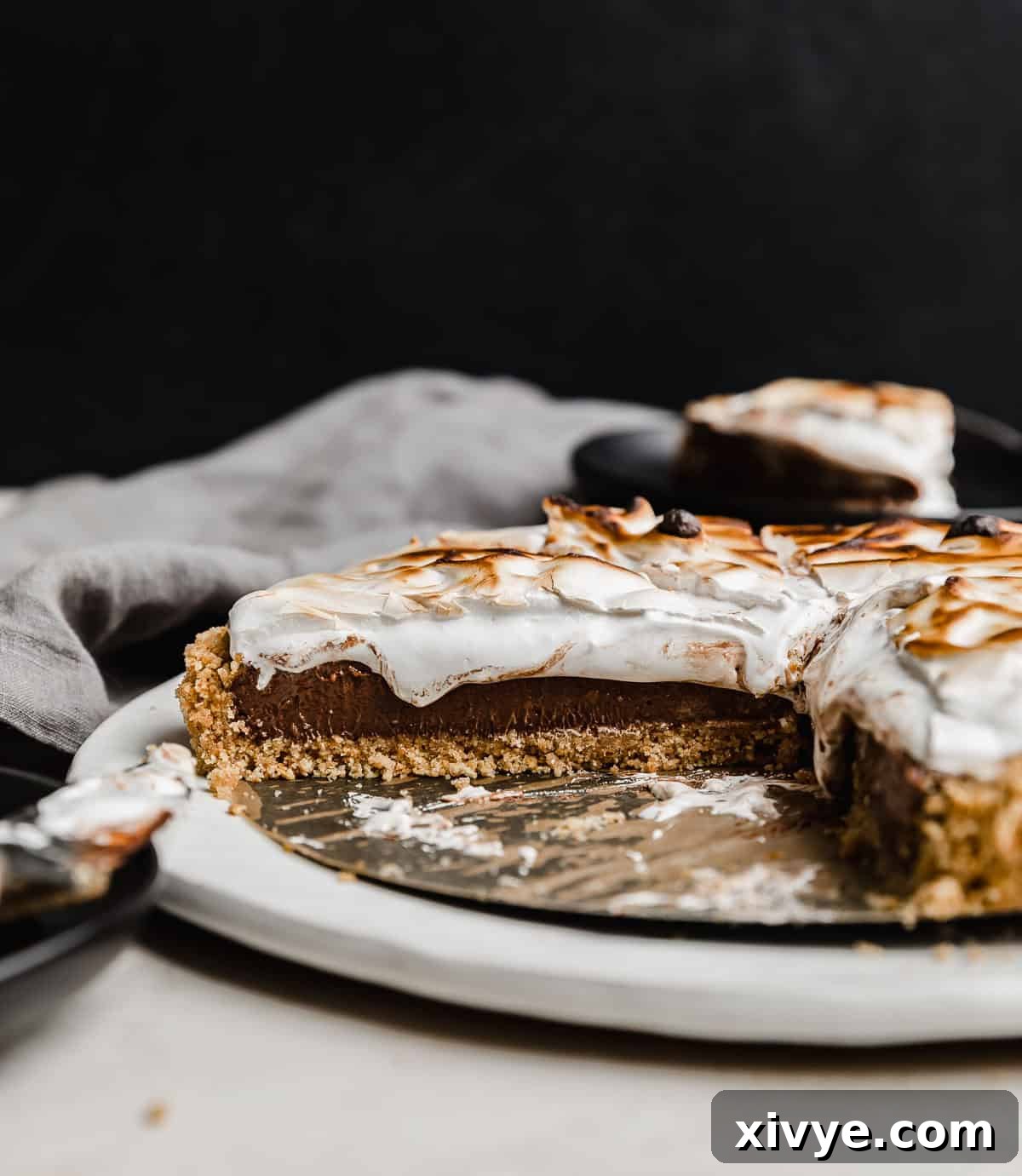 A S'mores Pie recipe made with graham cracker crust, chocolate pudding, and marshmallow cream, against a black background.