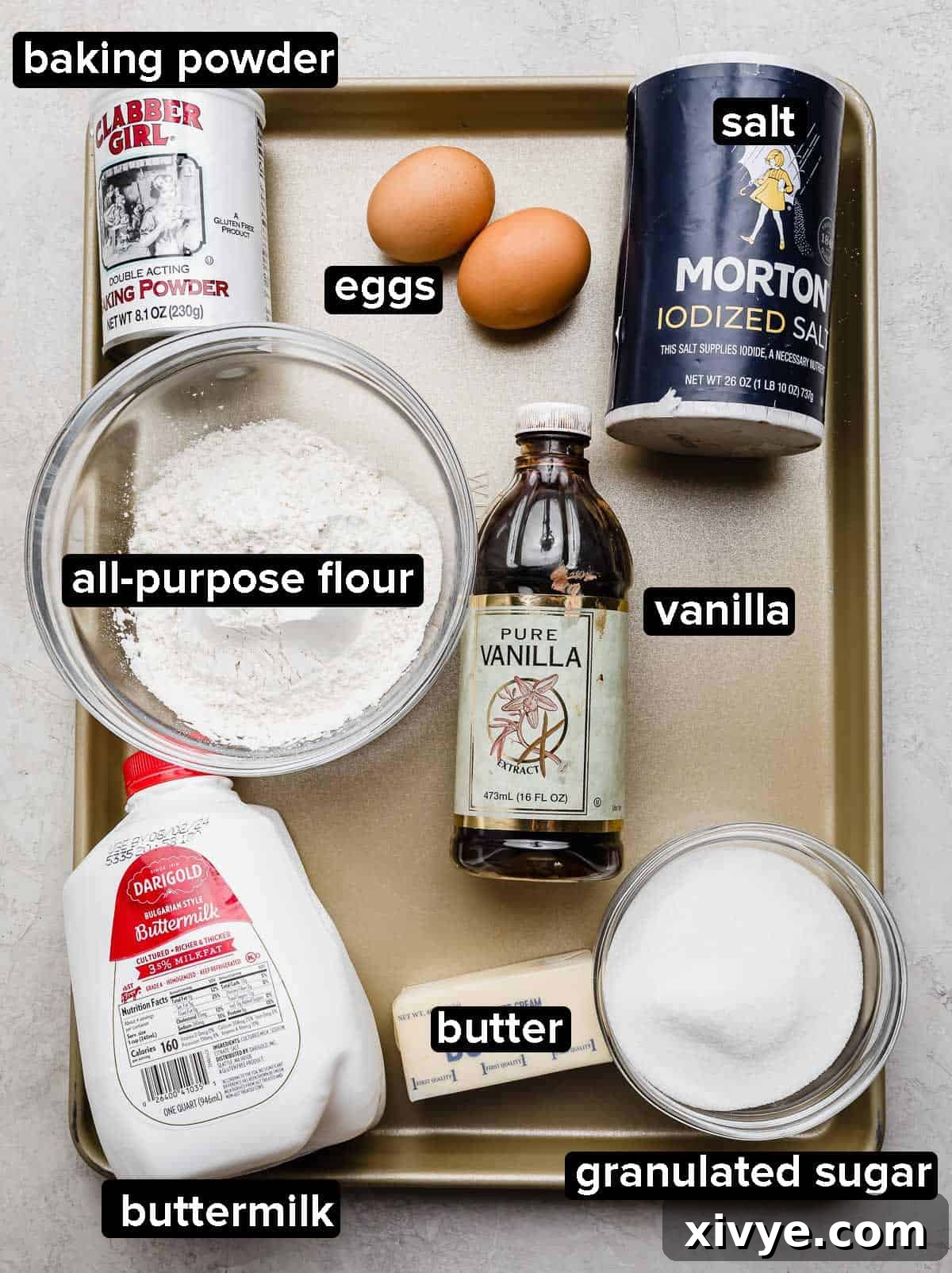 Decadent Nutella Swirl Cupcakes 3 Nutella Cupcake recipe ingredients on a gold baking sheet: buttermilk, salt, flour, sugar, butter, baking powder, eggs, and vanilla extract.