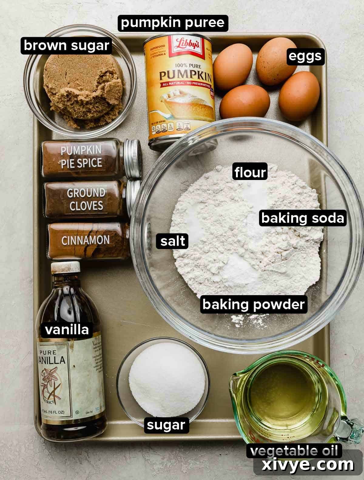 Moist Pumpkin Bundt Cake recipe ingredients portioned into some glass bowls on a silver baking sheet.