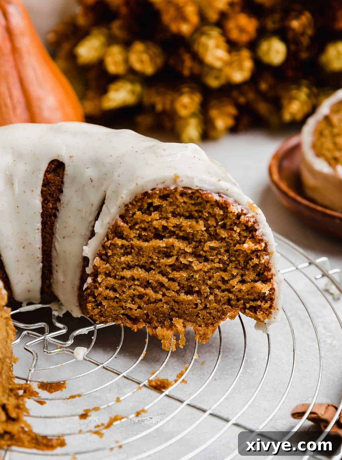 A slice of pumpkin bundt cake topped with brown butter glaze.