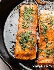 Honey-Kissed Lemon Salmon 6 Seared Lemon Honey Glazed Salmon in a black skillet, garnished with herbs.