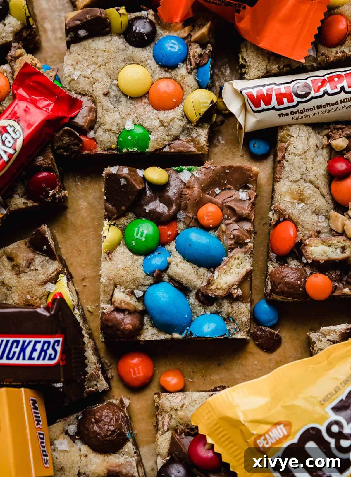 Monster Mash Candy Cookie Bars 2 Leftover Halloween Candy Cookie Bars topped with colorful M&M's, chopped Snickers, Kit Kat, Milk Duds, Reese's, and more! A vibrant and irresistible display of post-Halloween delight.