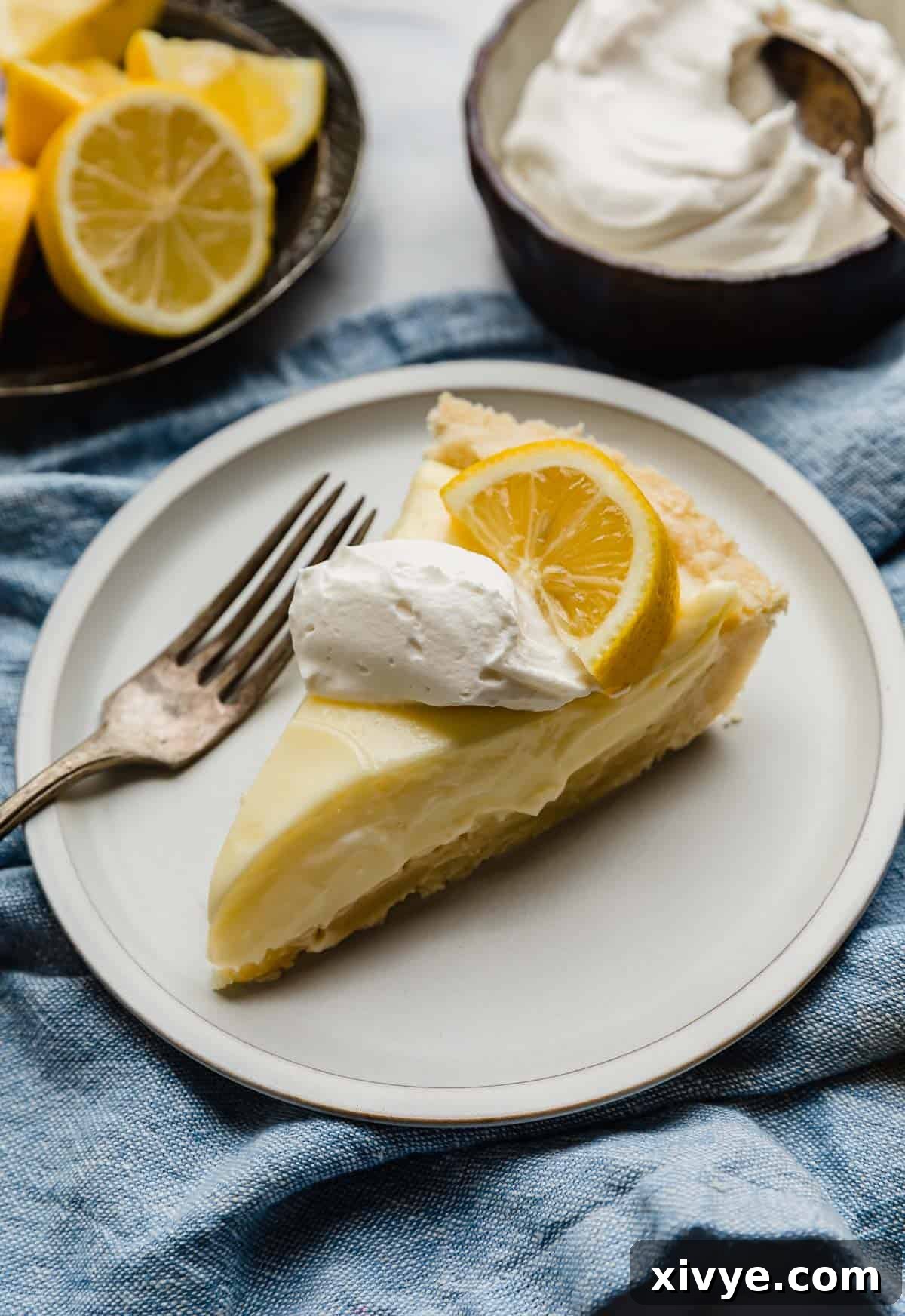 Tangy Lemon Dream Pie 2 A slice of the best Lemon Sour Cream Pie on a white plate.