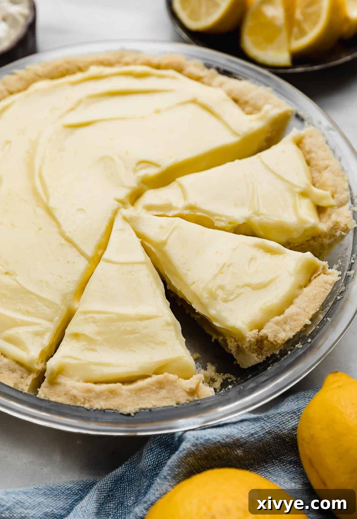 Tangy Lemon Dream Pie 6 Lemon sour cream pie filling in a shortbread pie crust, with three pie slices cut.