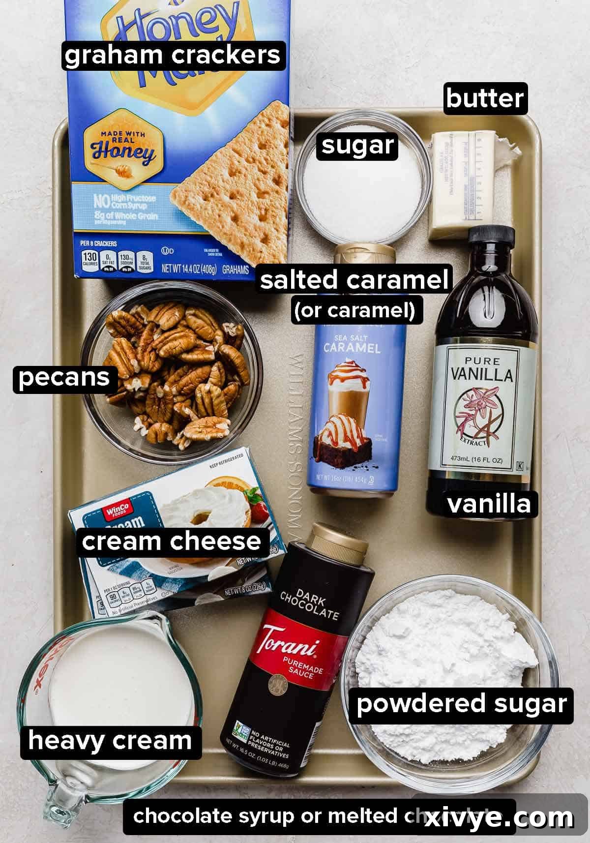 Decadent Turtle Pie 3 The best Turtle Pie recipe ingredients on a gold baking sheet: salted caramel, pecans, sugar, graham crackers, cream cheese, heavy cream, vanilla and butter.