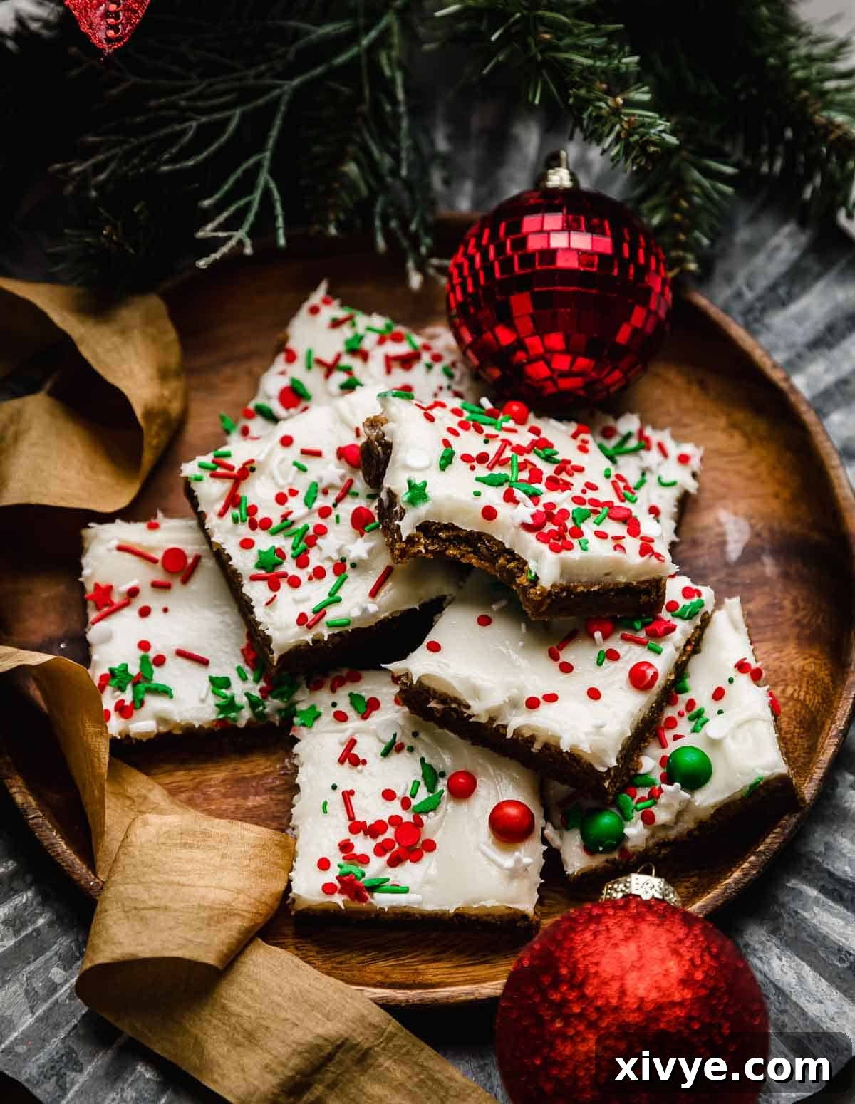 Warm Spiced Ginger Bars 8 A bite taken out of a frosted Gingerbread Cookie Bar on a brown plate.