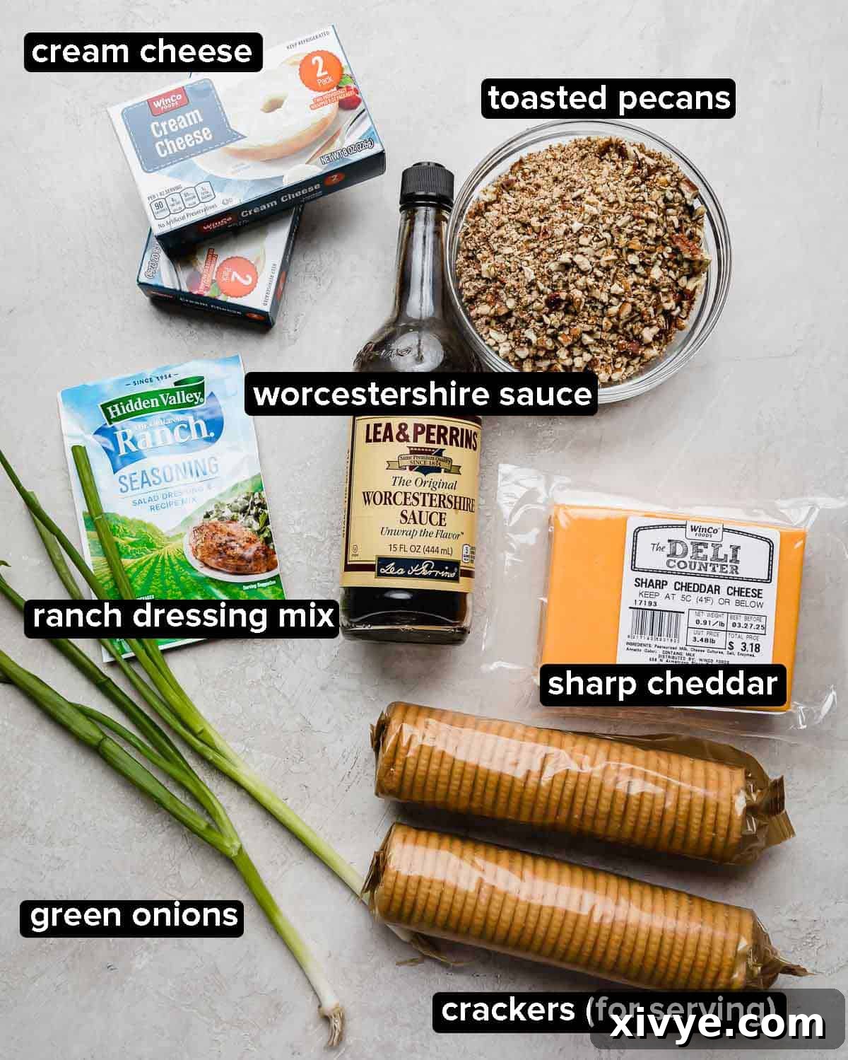 Christmas Cheese Ball ingredients on a light gray background: pecans, cheese, cream cheese, green onions, ranch seasoning, and Worcestershire sauce.