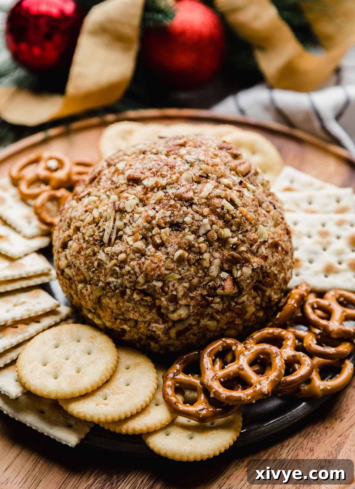 Pecan covered cheese ball with ranch seasoning on a brown plate.