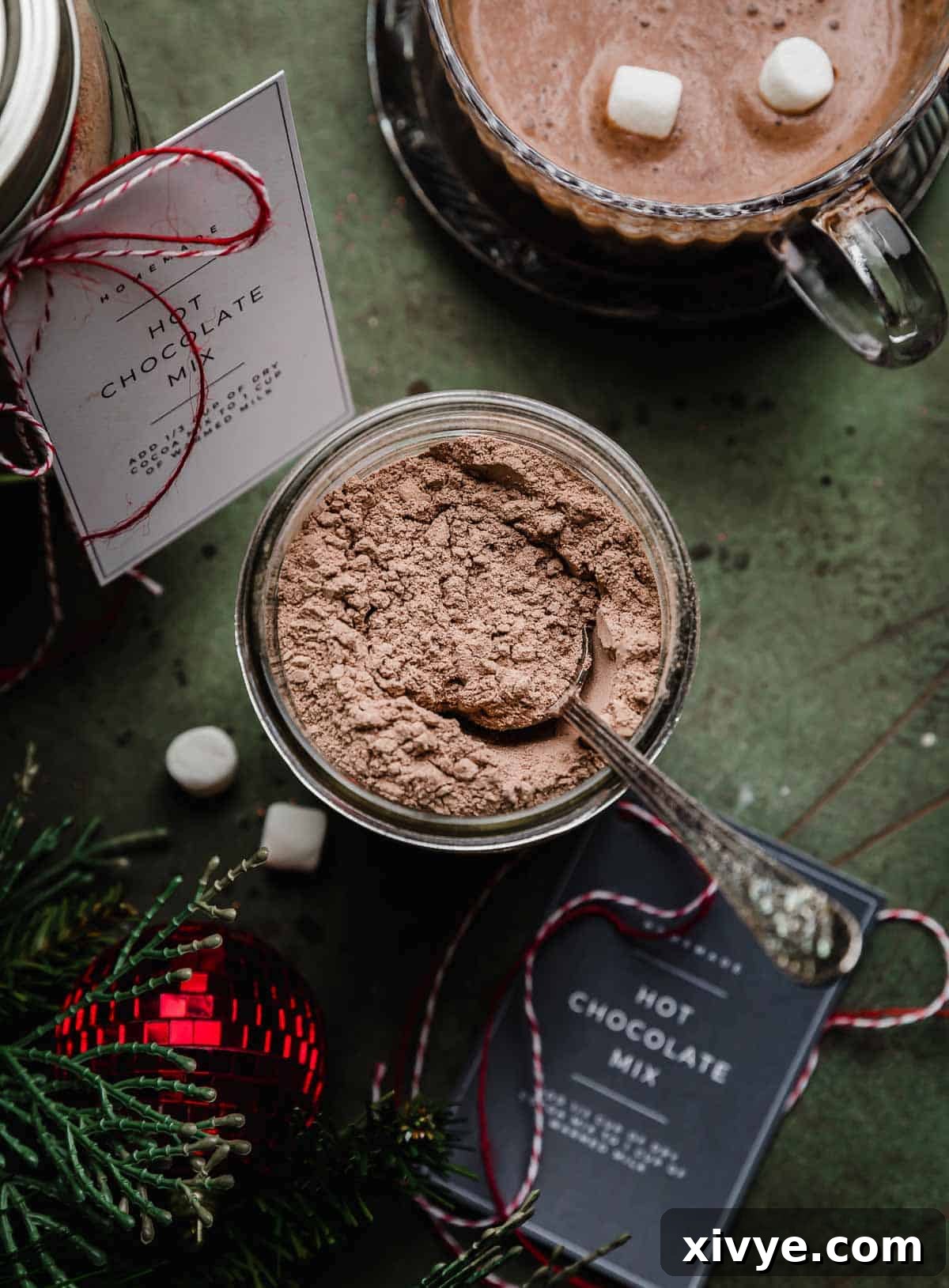 Premium Homemade Hot Chocolate Blend 2 Overhead photo of Homemade Hot Cocoa Mix in a glass mason jar on a dark forest green background.