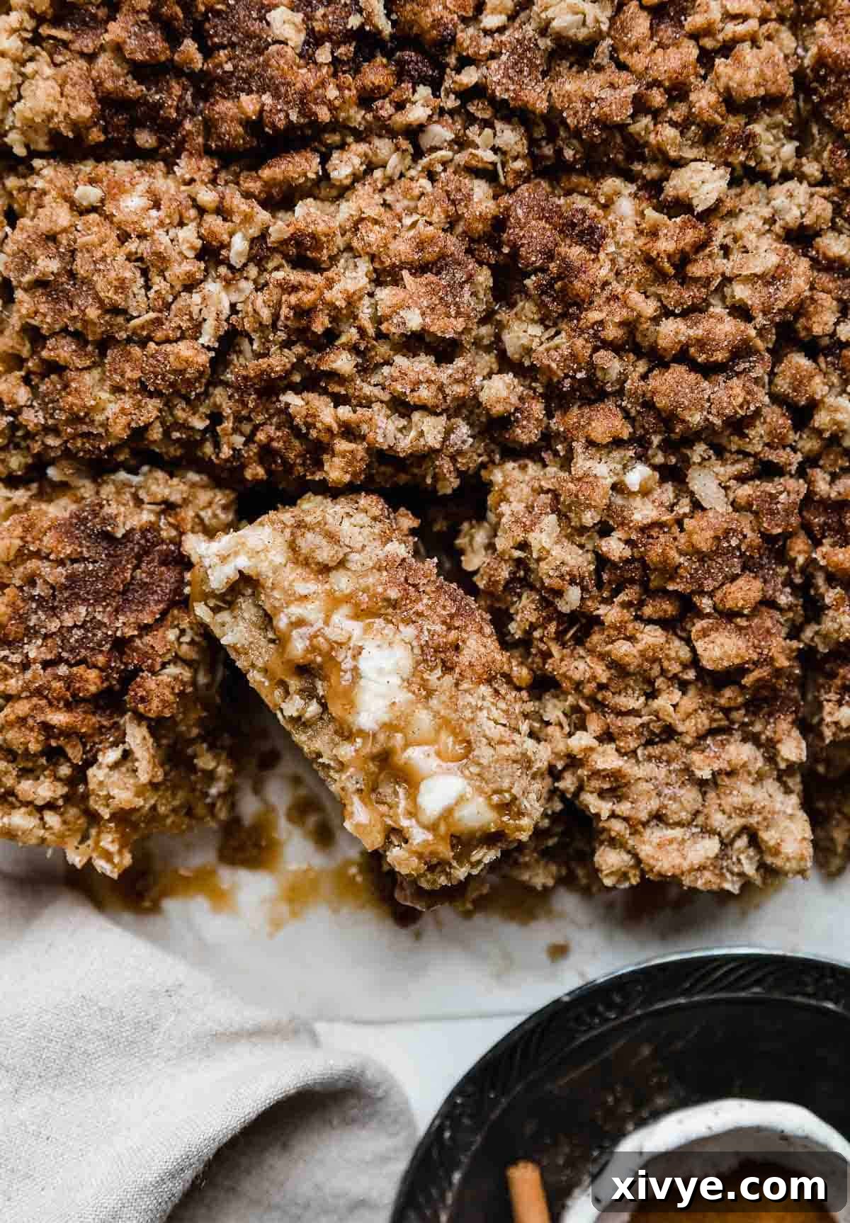 A white chocolate snickerdoodle carmelita cut into squares on a white parchment paper.