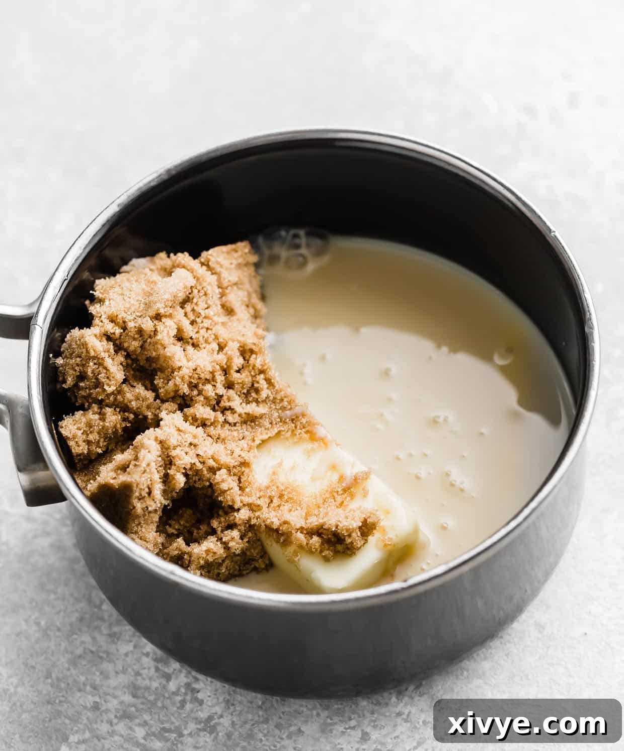 Decadent Caramel Apple Indulgence 5 A saucepan showing brown sugar, butter, and sweetened condensed milk being stirred together to make caramel dip.