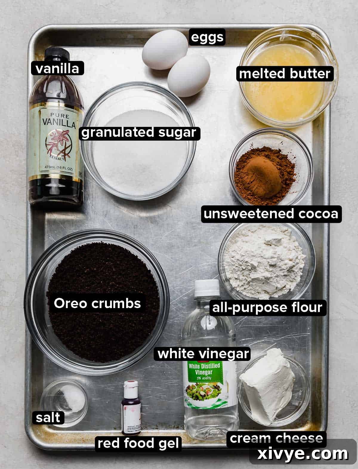Decadent Red Velvet Oreo Truffle Brownies 3 Red Velvet Oreo Truffle Brownies ingredients portioned into glass bowls on a silver baking sheet on a white background.