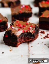 Decadent Red Velvet Oreo Truffle Brownies 9 A chocolate covered red velvet brownie topped with Oreo truffle with a bite taken out of the Valentines inspired brownie.