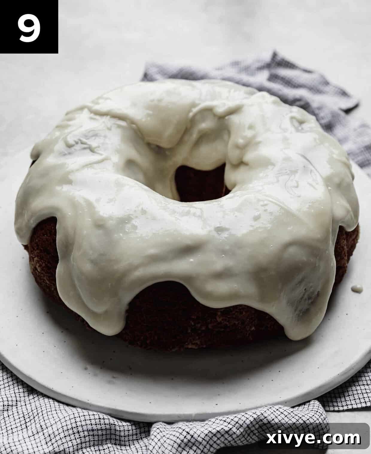 Crimson Crown Bundt 6 Cream cheese glazed Red Velvet Bundt Cake on a white plate.