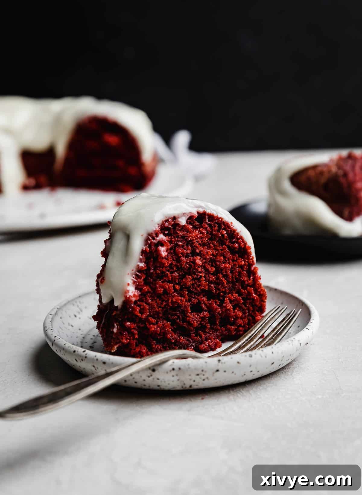 Crimson Crown Bundt 8 A slice of Red Velvet Bundt Cake on a white plate.