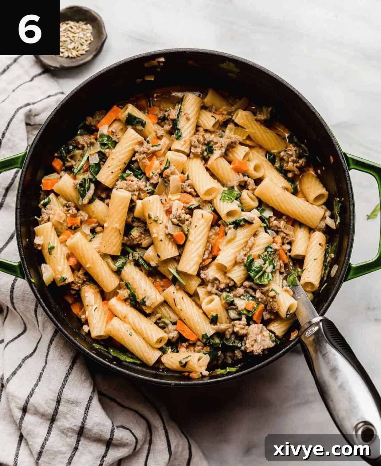Hearty Italian Sausage Rigatoni 6 The best Italian Sausage Rigatoni recipe with spices and spinach in a large dutch oven with a large silver serving spoon in the pasta.