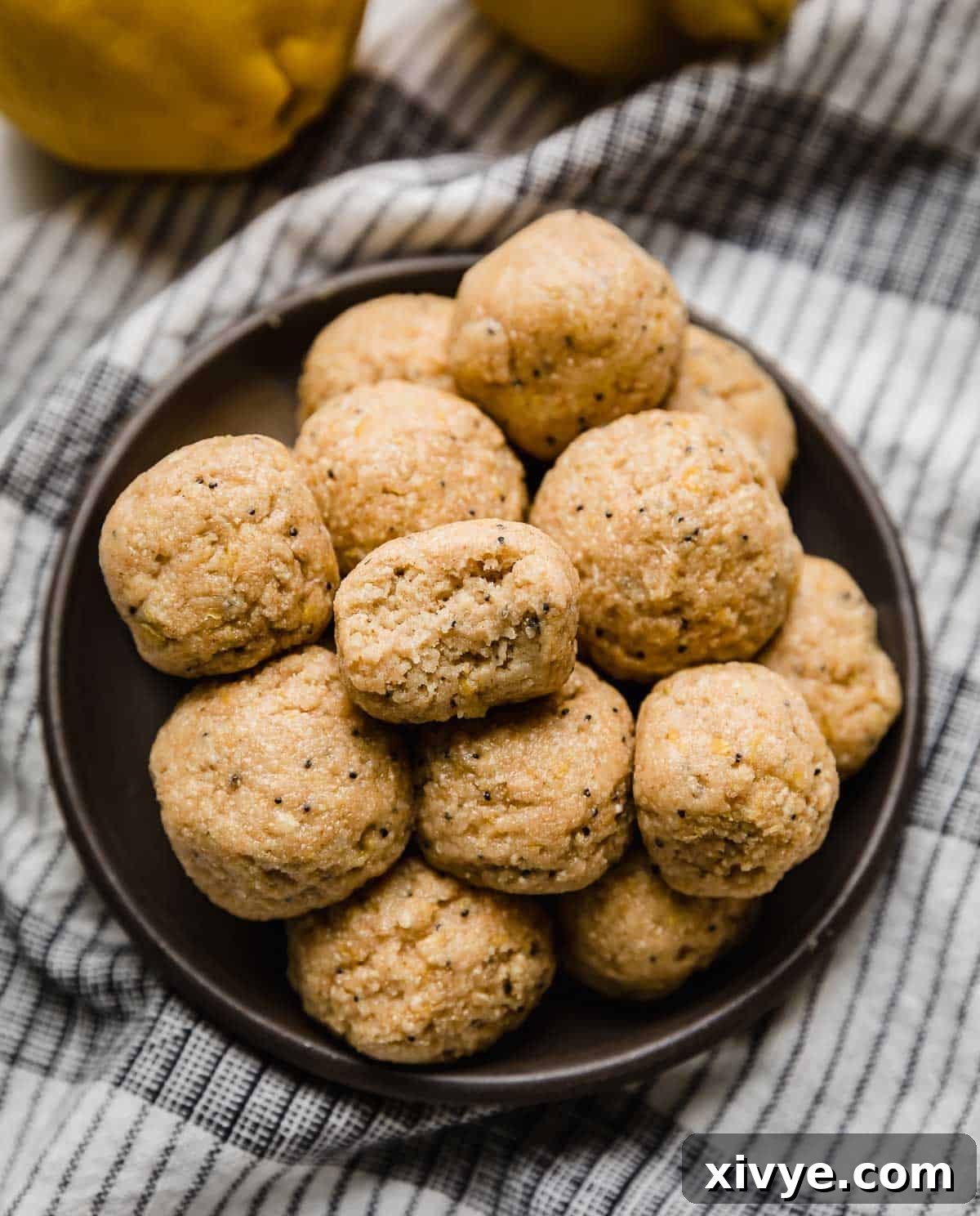 A black plate piled with Lemon Protein Balls on it.