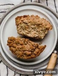 Easy banana bread muffin on a white plate, cut in half.