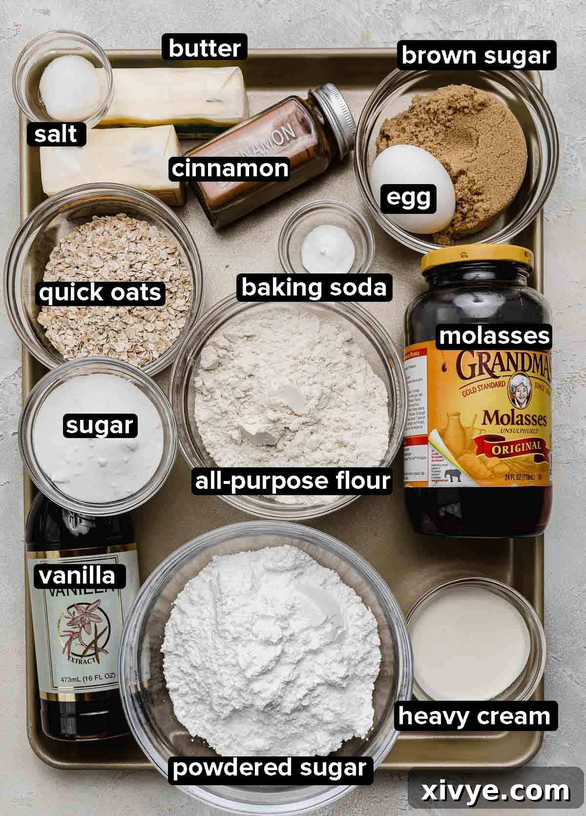 Homemade Oatmeal Creme Pie ingredients neatly portioned into glass bowls on a gold baking sheet, ready for mixing.