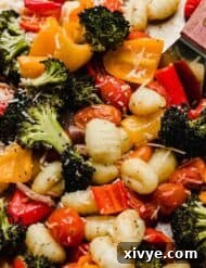 Easy roasted gnocchi and vegetables on a sheet pan: broccoli, peppers, red onion, and tomatoes.