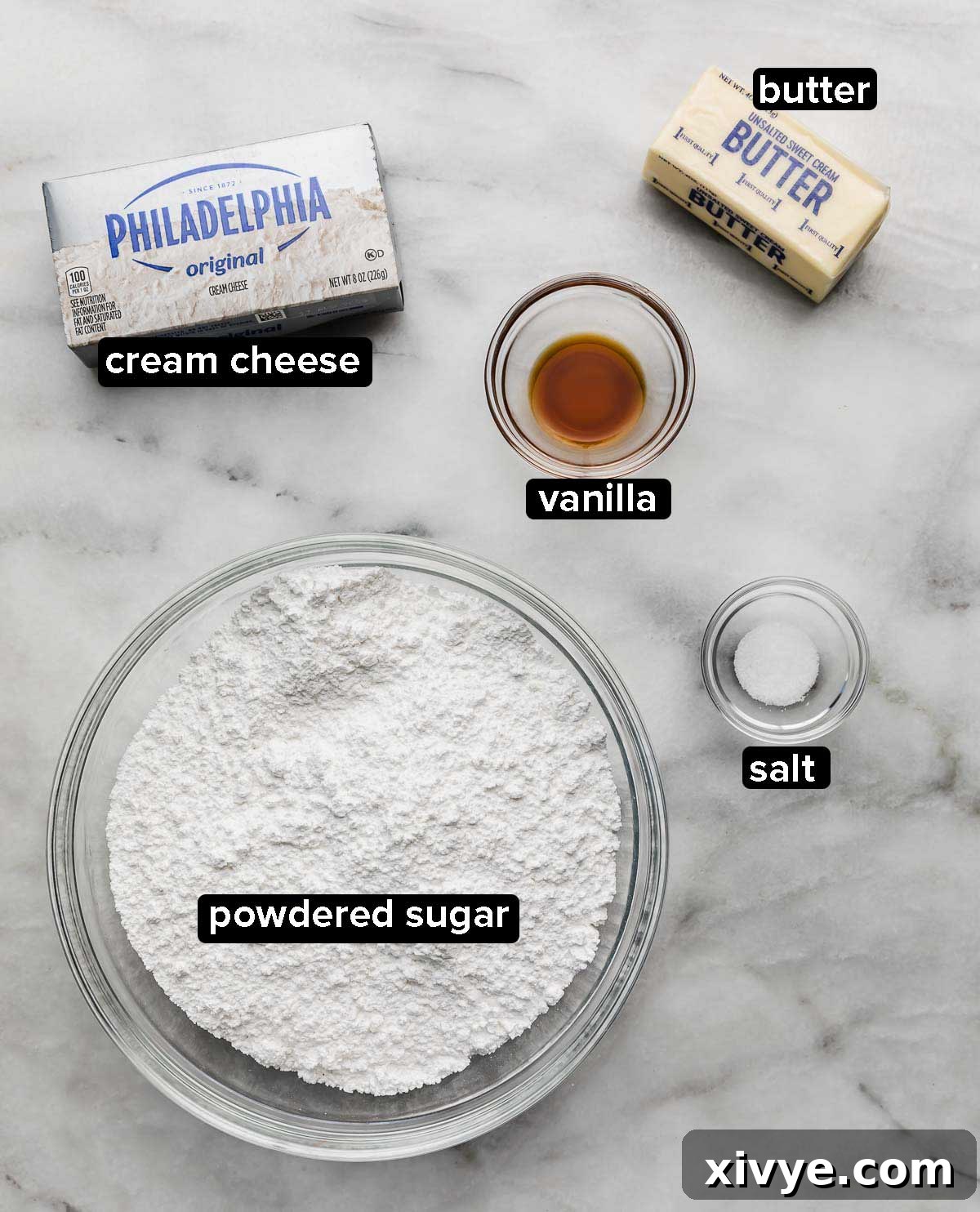 Brown Butter Cream Cheese Frosting ingredients on a white and gray marble surface: powdered sugar, cream cheese, vanilla, butter, salt.