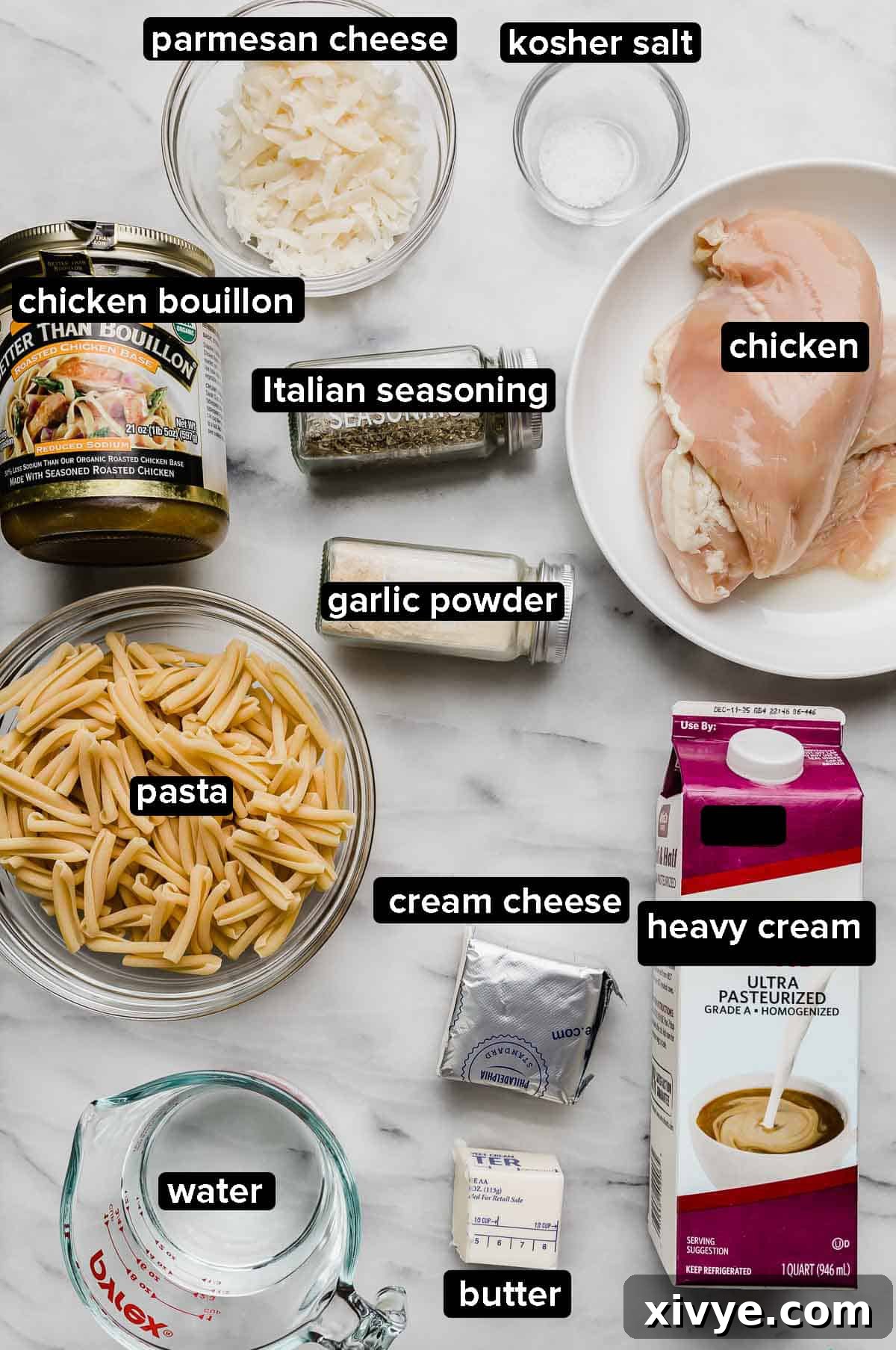 Ingredients used to make an Easy Crock Pot Chicken Alfredo recipe: raw chicken, cream cheese, heavy cream, water, pasta, chicken bouillon, cheese, and dry seasonings.