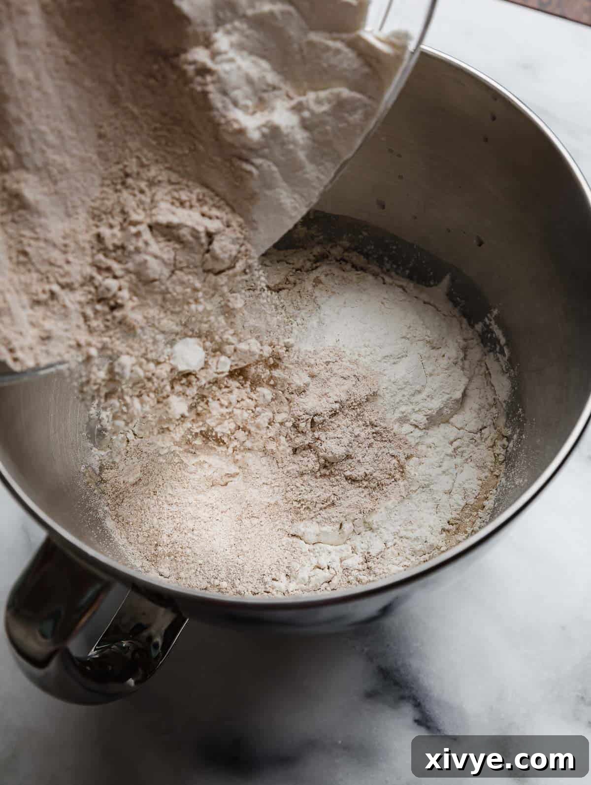 Fifty-Fifty White and Whole Wheat Bread 6 Half white flour half whole wheat flour dry ingredients being added to wet ingredients to make 50/50 bread dough.