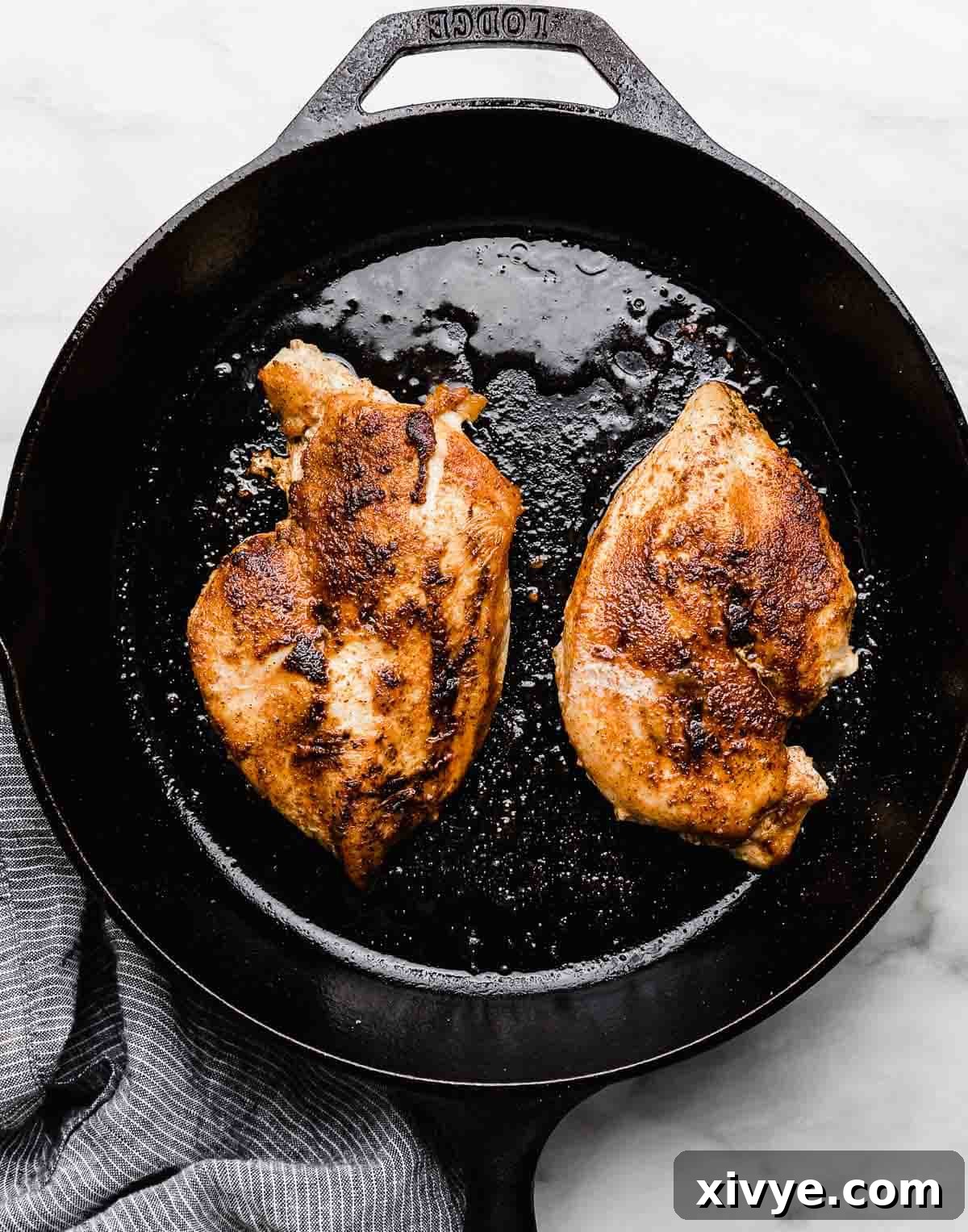 Effortless Bang Bang Chicken Bowls 5 Cooked and seasoned chicken breasts in a black skillet.