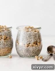 Overnight Oat Milk Chia Pudding 8 Chia pudding in a jar that's layered with granola, against a white background.